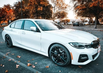 Image of a four door white BMW parked.