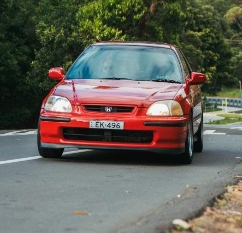 Image of a red Honda Civic driving on the road.